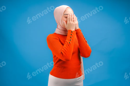 Preview: Religious beautiful Asian Muslim woman wearing a headscarf is praying to God.