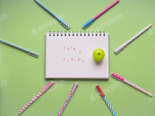 Preview: White notebook on green. Back to school