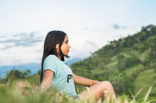 Preview: beautiful latin girl, sitting on the top of a hill enjoying the beautiful colombian landscape.
