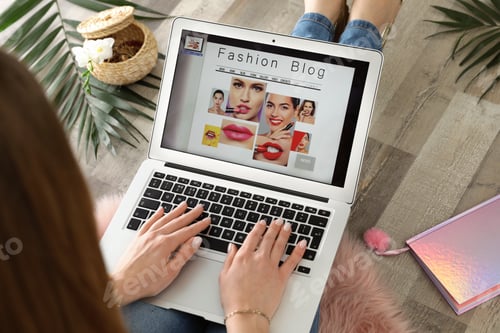 Preview: Woman holding laptop with open fashion blogger site on floor, closeup