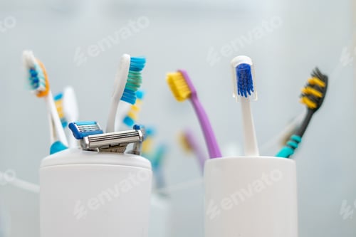 Preview: a set of some colorful toothbrushes razor blades on the shelf in bathroom, personal accessories