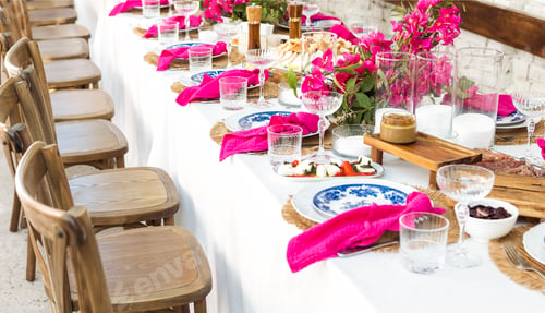 Preview: A set festive table in the open air. The table is decorated with candles and flowers.