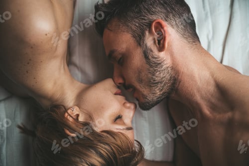 Preview: Sensual and romantic young couple kissing and making love on the bed at home.