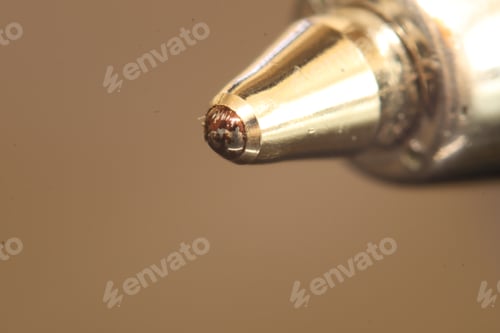 Preview: Close-Up of a Metallic Ballpoint Pen Tip on Neutral Background