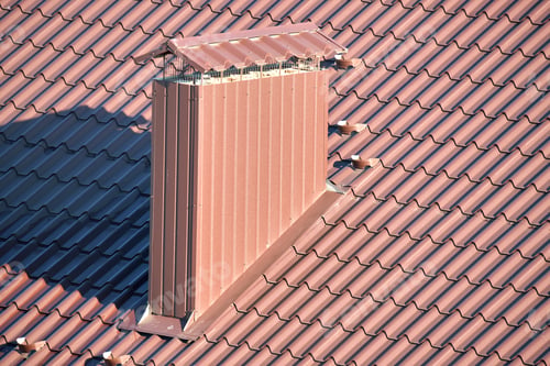 Preview: Chimney on house roof top covered with metallic shingles under construction. Tiled covering of