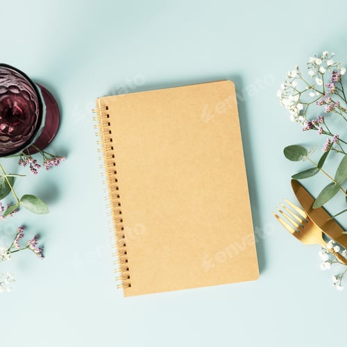 Vista previa: Notebook and table decorations on blue background. Flat lay top view copy space mockup