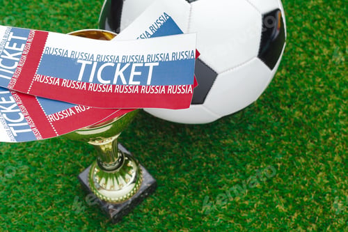 Preview: Soccer match tickets and trophy placed on green grass