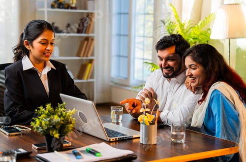 Preview: Indian married young couple showing excitement and happiness looking at laptop in an office