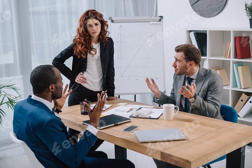 Preview: Financial adviser standing near table with laptop and papers while two businessmen arguing with her