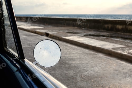 Preview: Side mirror of the car with sea view