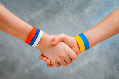 Preview: Reconciliation concept and handshake. Children's Hands with drawing flag of Ukraine and Russia