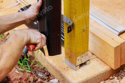Preview: Before installing aluminum rain gutters, a worker cuts them with metal shears