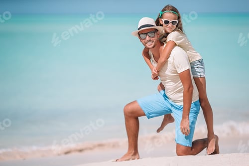 Preview: Little girl and happy dad having fun during beach vacation