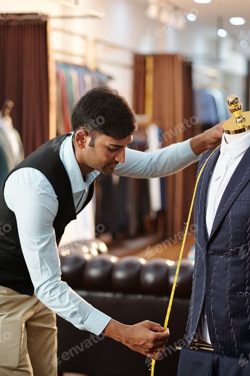 Preview: Focused Tailor Measuring a Suit in his Shop
