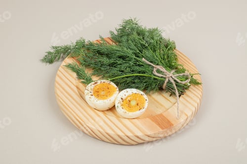 Preview: A wooden board of boiled egg with spices and greens