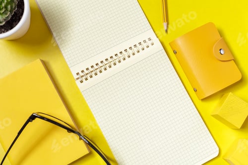 Preview: Bright yellow workspace with notebook, glasses, and plant on table