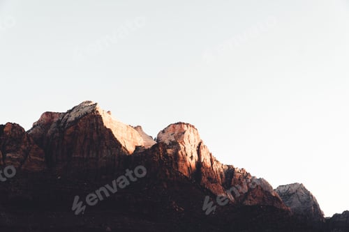 Preview: Low-angle shot of a mountain silhouette with the white sky in the background