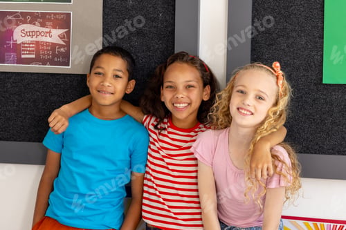 Preview: In school, diverse group of young friends are sitting together in a classroom, smiling