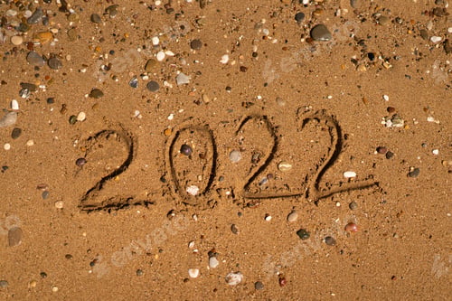 Preview: 2022 is drawing on sand on a beach with a wave by the sea. Vacation on the sea. New Year concept