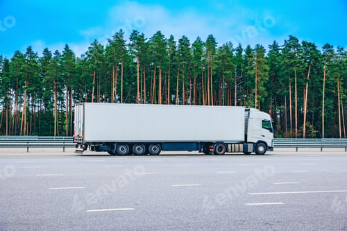 Preview: Large White Truck Parked on the Side of a Highway Surrounded by Dense Green Forests