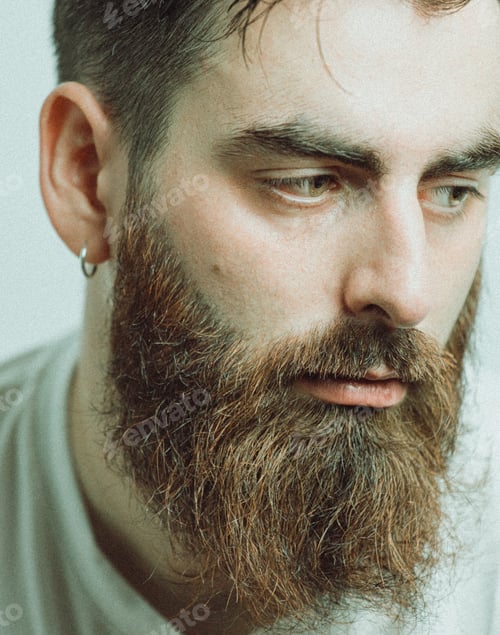 Preview: Frontal cinematic portrait of a handsome man with beard. Looking serious and worried