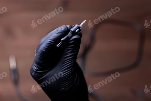 Preview: the hands of a permanent makeup artist in black medical gloves