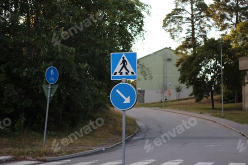 Preview: Beautiful shot of blue street signs near a green forest during the day