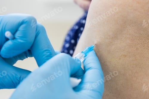 Preview: Senior woman receiving vaccine. Medical worker vaccinating an elderly patient against flu, influenza