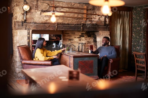 Preview: Couple Meeting For Lunchtime Drinks In Traditional English Pub