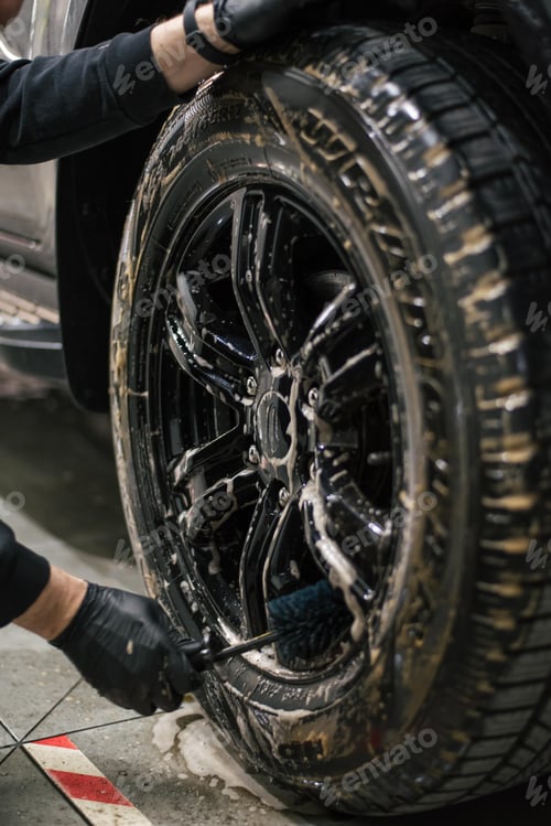 Preview: Closeup of a mechanic performing a detailed tire cleaning on a car's rim, using specialized tools