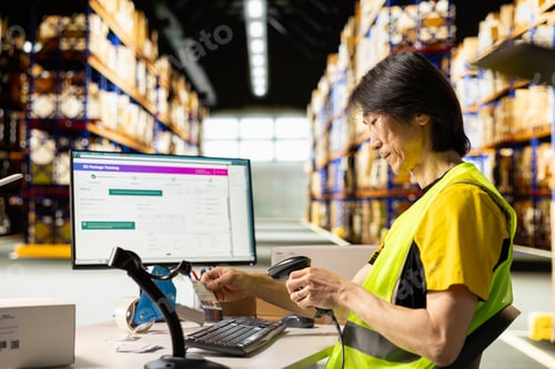 Preview: Asian male worker scanning shipment labels and tracking numbers