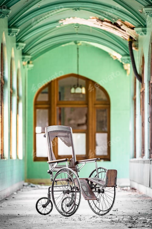 Preview: Vertical shot of a broken metallic wheelchair
