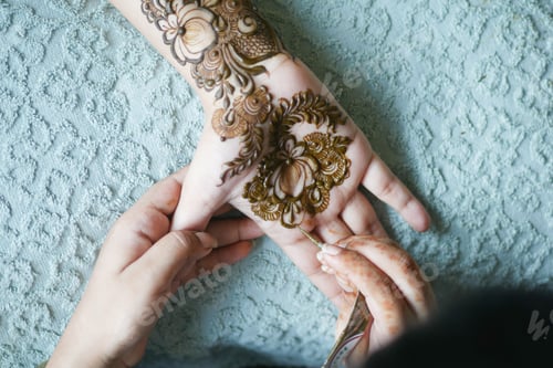 Preview: women applying henna on hand