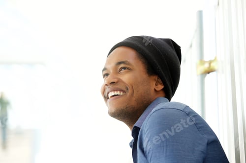Preview: Close up side of handsome young black man smiling and looking away