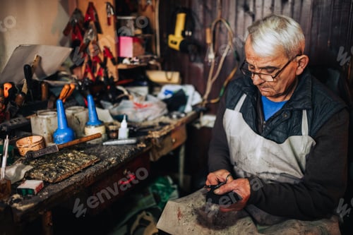 Preview: An artisan is cutting leather parts and preparing it for shoe making.