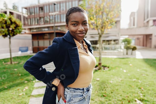 Preview: Stylish african female student near university campus.