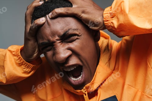 Preview: Young black man in sports jacket screaming while holding his head
