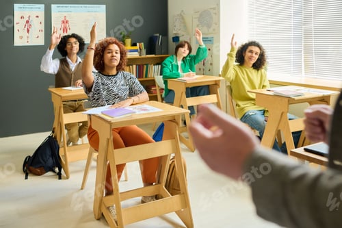 Preview: Group of intercultural teenage students of high school raising hands at lesson