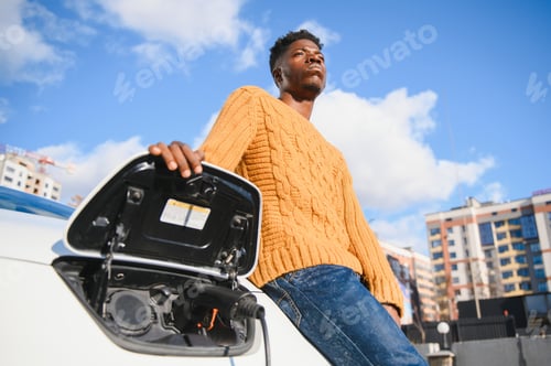 Preview: Electric cars, EV concept, eco friendly fuel. Portrait of young smiling black man