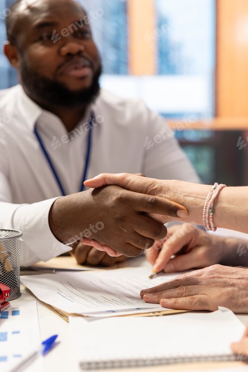Preview: Broker expert shaking hands with elderly client after signing a retirement plan