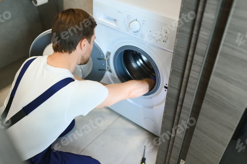 Vista previa: un fontanero que trabaja repara una lavadora
