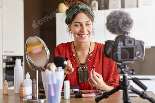 Preview: Video blogging concept. Attractive young woman sitting in shooting area, having web television suppo