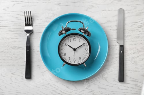 Preview: Flat lay composition with alarm clock, plate and utensils on light background