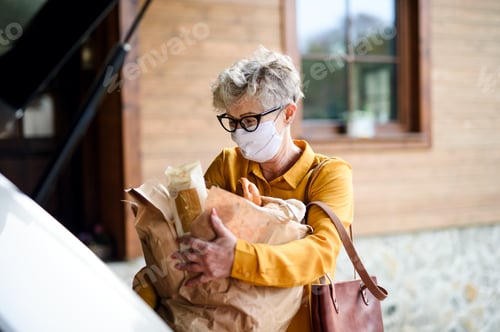 Preview: Senior woman with face mask outdoors with shopping, corona virus and quarantine concept