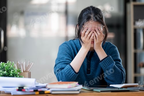Preview: Stressed business woman working from home on laptop looking worried and tired from hard work.