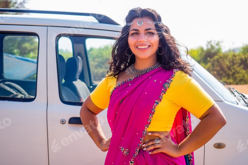 Preview: Portrait of young Indian woman in a traditional pink sari and costume jewelry o