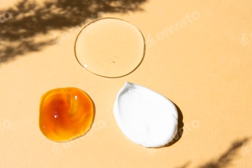 Preview: Cosmetic textures of different colors on a beige background top view. Body cream, soap, lotion care