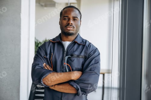 Preview: Front view, standing with arms crossed. Repairman is indoors in the modern office