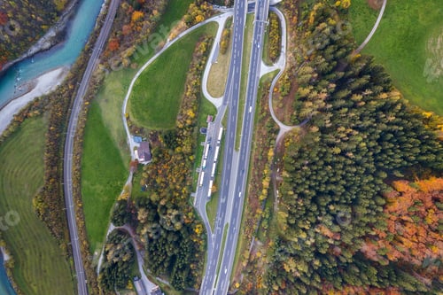 Preview: Top dawn aerial view of freeway speed road between yellow autumn forest trees and blue river