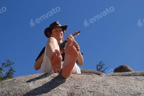 Preview: Woman playing ukulele, outdoors